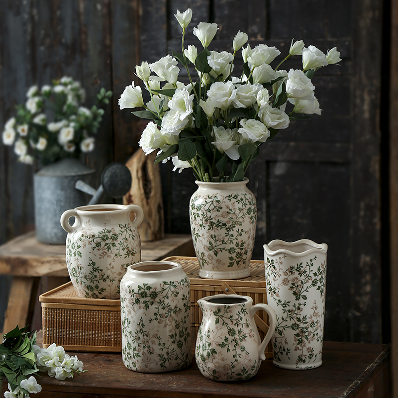 Retro ceramic vase decoration with floral arrangements on rustic table, showcasing green and white color scheme.